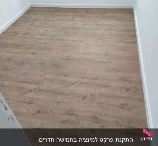 רצפת פרקט עץ בחדר עם קירות לבנים